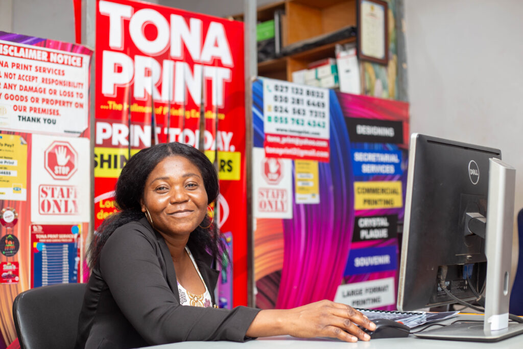A lady smiling behind a computer